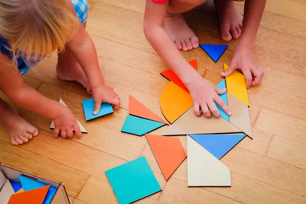 Kinder lernen - kleine Jungen und Mädchen spielen mit geometrischen Formen — Stockfoto