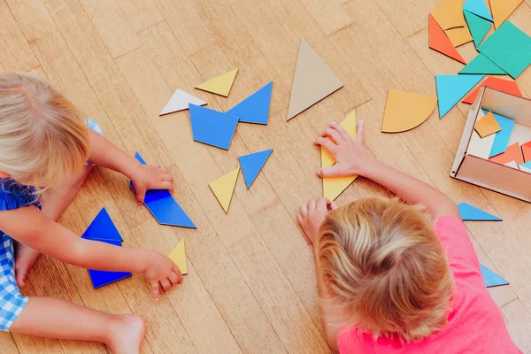 Barn lärande - liten pojke och flicka som leker med geometriska former — Stockfoto