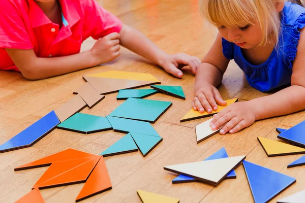 Çocuklar öğrenme - küçük erkek ve kız geometrik şekillerle oynamak — Stok fotoğraf