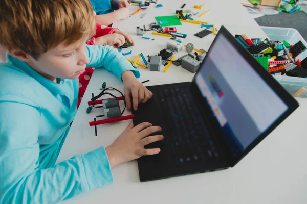 Çocuklar robot yapıyor ve bilgisayarda programlıyorlar.