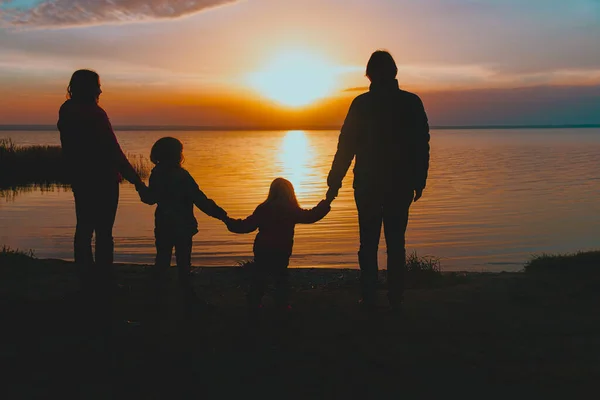 Família feliz com crianças na costa do por do sol no inverno — Fotografia de Stock