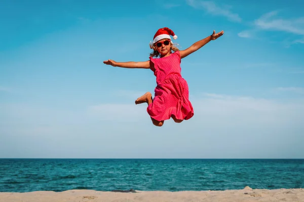 Süßes kleines Mädchen feiert Weihnachten am tropischen Strand — Stockfoto
