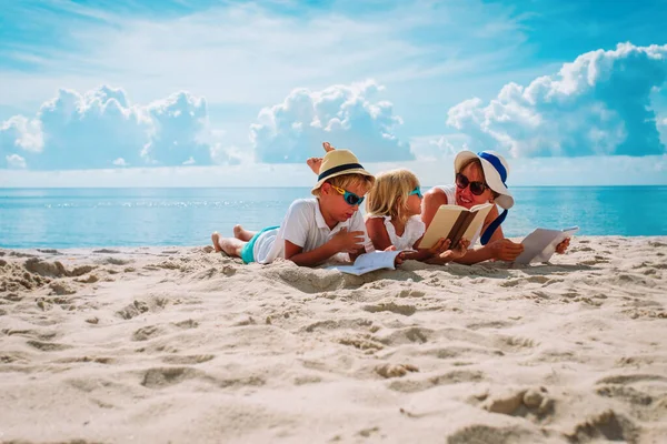 Mutter mit Sohn und Tochter lesen Bücher am Strand — Stockfoto