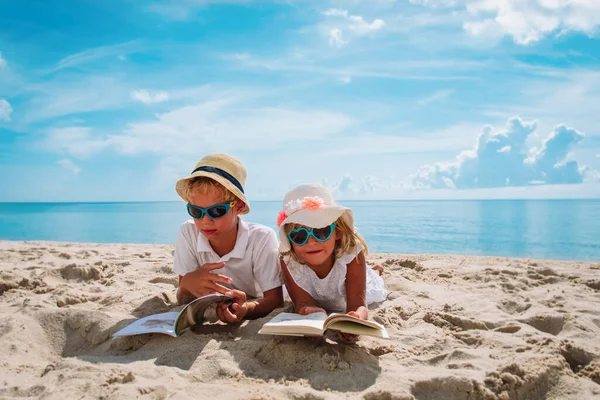 Chłopiec i dziewczyna czytać książki na plaży, rodzinne wakacje — Zdjęcie stockowe