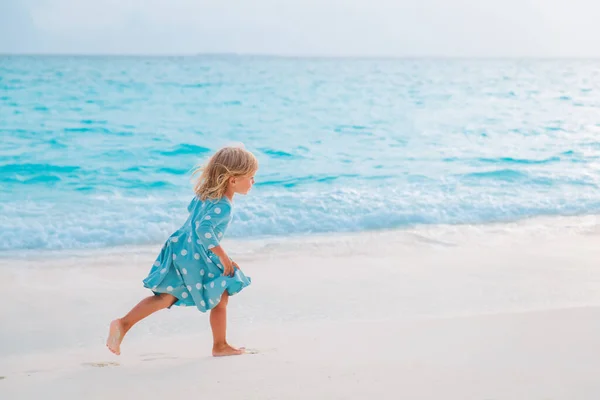 Šťastná holčička běží a hrát na tropické pláži — Stock fotografie
