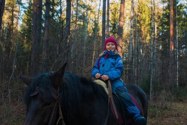 Niña feliz a caballo en el bosque — Foto de Stock