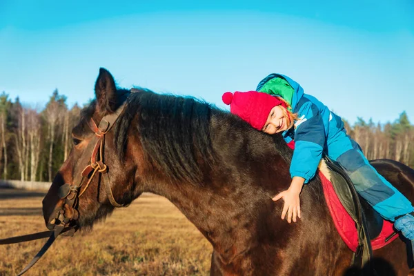 Glückliche kleine Mädchen umarmen Pferd, Pferdetherapie — Stockfoto