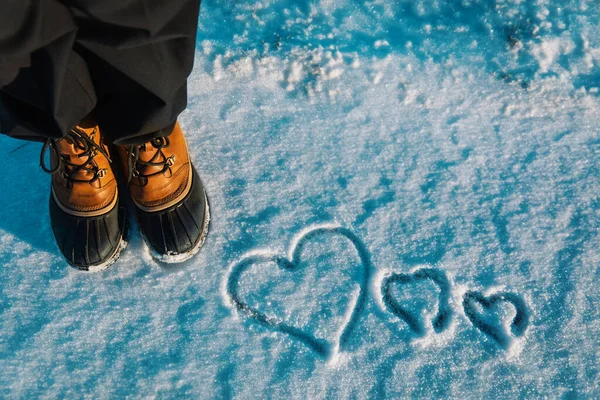 Liefde winter concept- voeten in sneeuwschoenen en hart in de natuur — Stockfoto