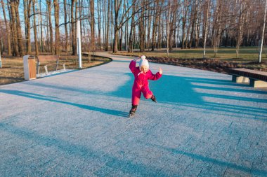 Küçük kız bizim tarafımızda paten numaraları öğreniyor.