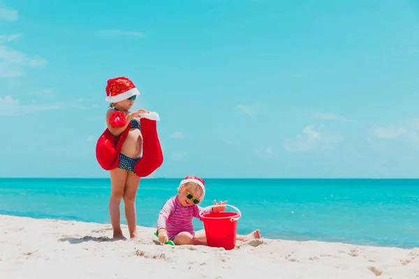 Noel 'i tropikal plajda kutlayan tatlı küçük kızlar. — Stok fotoğraf