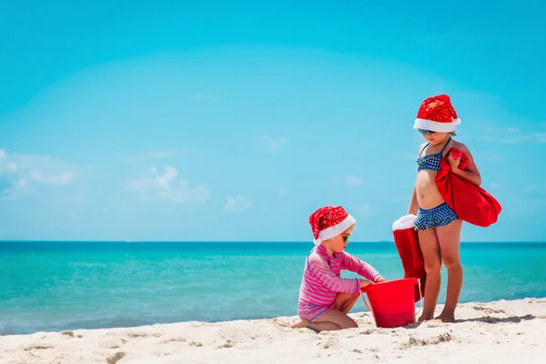 Niñas lindas celebrando la Navidad en la playa tropical —  Fotos de Stock