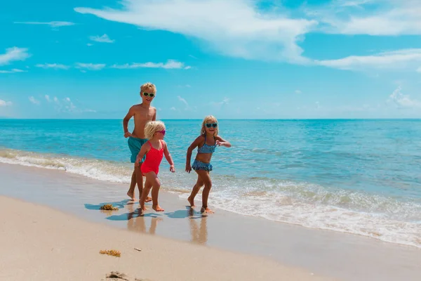 Gelukkig kinderen genieten strand vakantie, jongen en meisjes veel plezier — Stockfoto