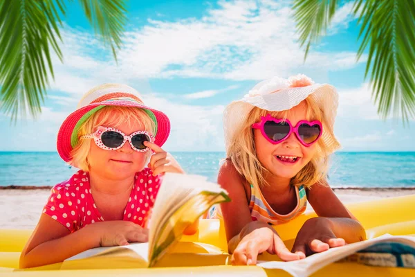 Petites filles lisent des livres sur la plage, vacances en famille — Photo