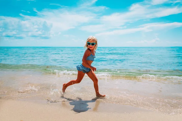 Gelukkig schattig meisje run en spelen op strand vakantie — Stockfoto