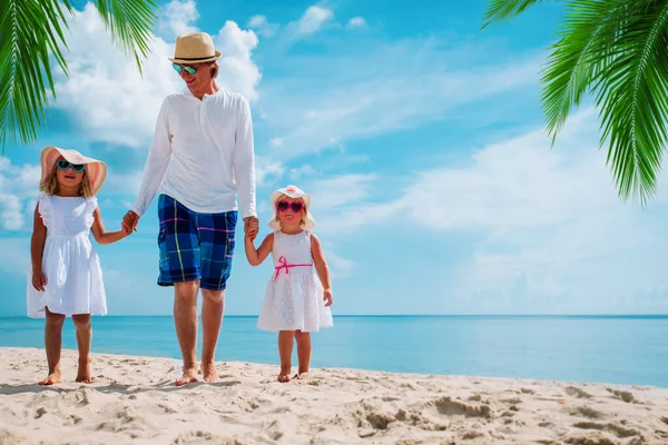 Gelukkig vader met twee leuke dochter wandelen op het strand — Stockfoto