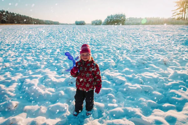 Carino bambina fare palle di neve con giocattolo plastica maker in inverno natura — Foto Stock