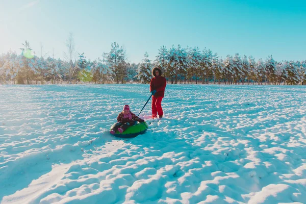 Πατέρας και μικρό κορίτσι ιππασία στο σωλήνα, οικογένεια να διασκεδάσουν στη φύση το χειμώνα — Φωτογραφία Αρχείου