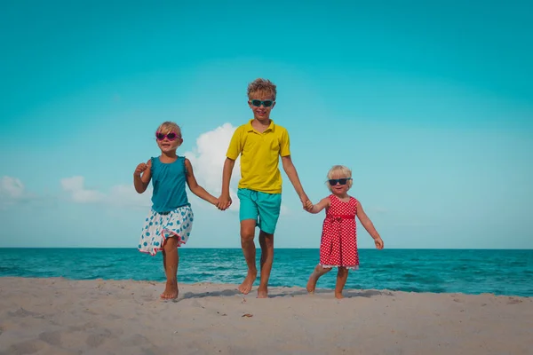 Gelukkig jongen en meisjesl lopen op strand vakantie — Stockfoto