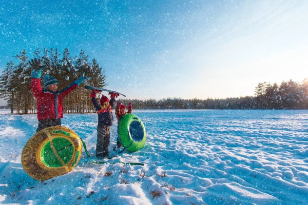 Gelukkige kinderen gaan glijden in de winter sneeuw, kinderen hebben plezier buiten — Stockfoto