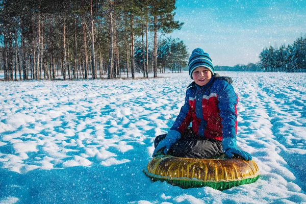 Gelukkig schattig jongen gaan glijden in de winter sneeuw — Stockfoto