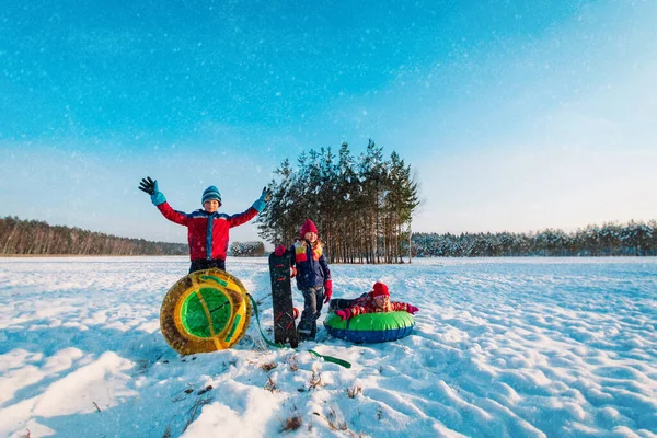 Szczęśliwy dzieci przejść do slajdów w śniegu zimowym, dzieci bawią się na zewnątrz — Zdjęcie stockowe