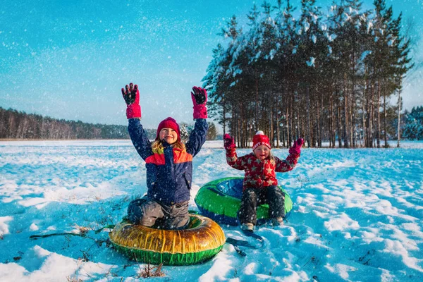 Szczęśliwy małe dziewczynki slajdów w śniegu zimowym, dzieci bawią się na zewnątrz — Zdjęcie stockowe