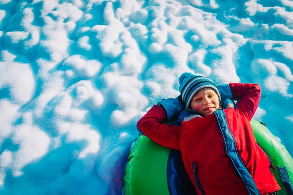 Glücklicher netter Junge genießt Rutsche im Winterschnee — Stockfoto