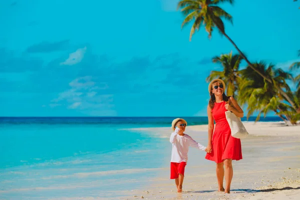 Gelukkig moeder met zoon lopen op tropische strand vakantie — Stockfoto