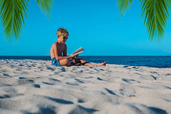 Αγόρι ανάγνωση βιβλίο στην παραλία άμμο, το παιδί μαθαίνει στις διακοπές — Φωτογραφία Αρχείου
