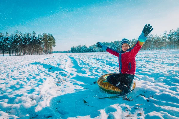 Glücklicher netter Junge, der im Winterschnee rutscht, Kinderhände in der Natur — Stockfoto