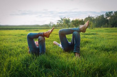 Erkek ve kız yeşil çimlerde dinleniyor, çocuklar yaz tatilinde.