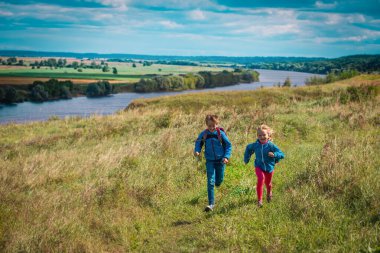 Mutlu çocuklar doğada oynar, kız ve erkek seyahatleri, aile tatilleri doğada