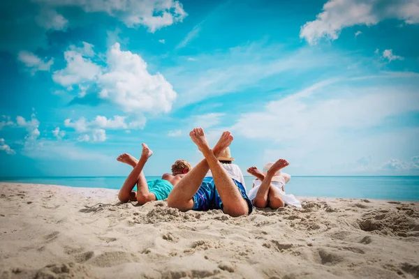 Vader met zoon en dochter ontspannen op het strand Stockafbeelding