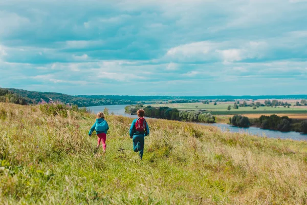 Gelukkige kinderen spelen in de natuur, jongen en meisje reizen, familie vakantie in de natuur Stockfoto