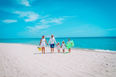 Üç çocuklu mutlu bir aile, plaj tatilinde.