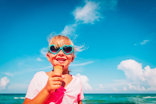 Kumsalda dondurma yiyen mutlu küçük kız. — Stok fotoğraf