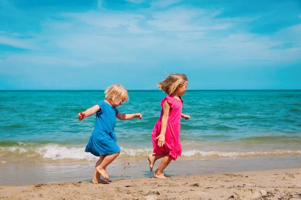 Счастливые милые девчонки бегают и играют на пляже — стоковое фото