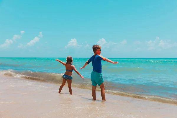 Счастливые мальчик и девочка наслаждаются отдыхом на море — стоковое фото
