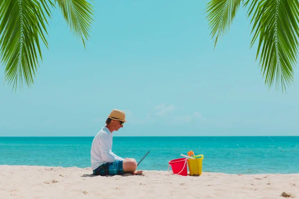 Uomo con computer portatile sulla spiaggia tropicale vacanza, vacanza in famiglia al mare — Foto Stock