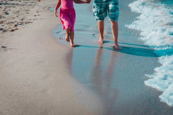 Far och dotter promenader på stranden lämnar fotavtryck i sand — Stockfoto