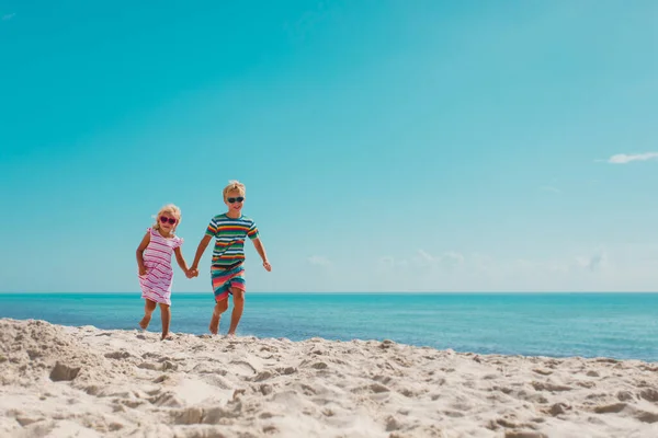 Děti běží, chlapec a dívka bavte se na tropické pláži — Stock fotografie