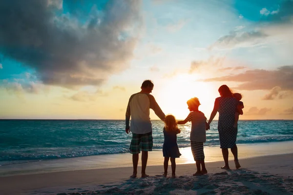 Gelukkig gezin met kinderen wandelen bij zonsondergang strand — Stockfoto