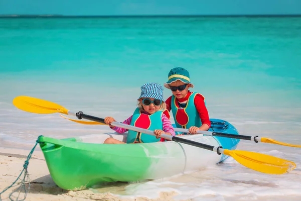 귀여운 소년 과 소녀 해변에서 카약을 타는 모습 — 스톡 사진