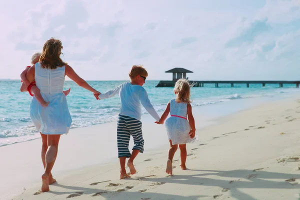 Madre e hijos disfrutan de vacaciones en la playa, la familia se divierten — Foto de Stock