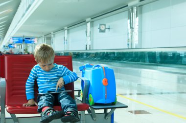 Havaalanında bekleyen dokunmatik yüzey ile küçük çocuk