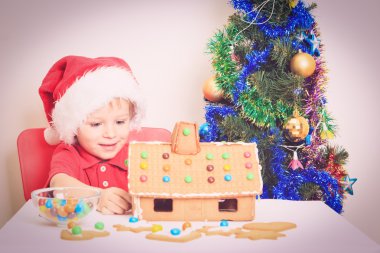 Noel babalar şapkalı gingerbread ev gülümseyen çocuk