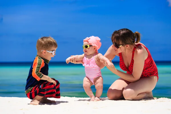 Moeder met kinderen spelen op tropisch strand — Stockfoto