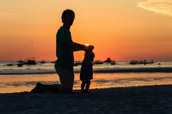 Silhueta de pai e pequena filha no pôr do sol — Fotografia de Stock