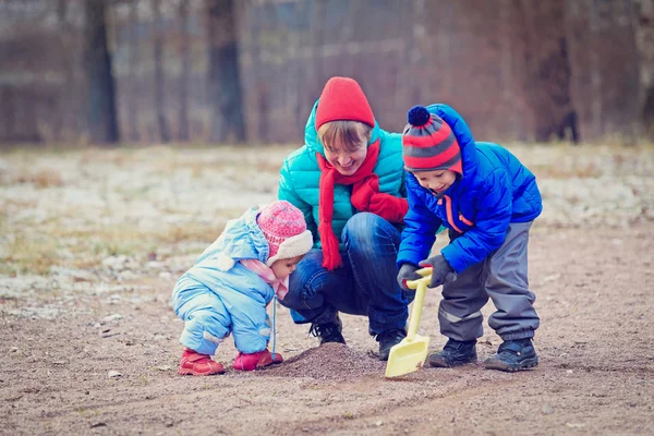 Мама с детьми, играющими зимой — стоковое фото