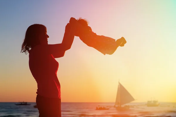 Мати і дочка розважаються на пляжі заходу сонця — стокове фото
